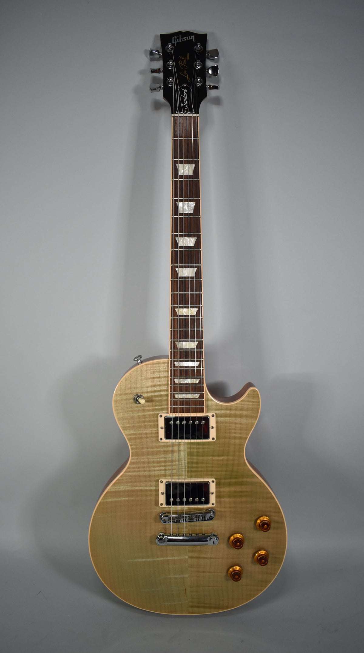 Full-length view of a flamed maple top Les Paul in Seafoam Green, with cream pickup rings, amber top hat knobs, and chrome hardware.