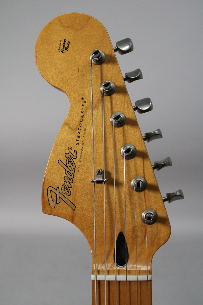 Close-up of the light brown headstock, angled slightly left, showing six silver tuners and a string tree.