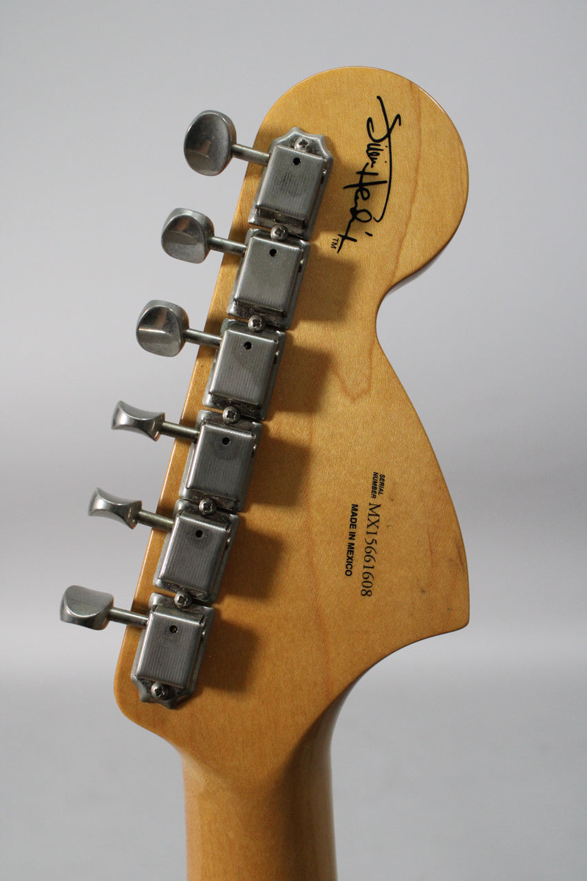 The light-colored headstock, viewed from the back, features six silver tuning machines and a black signature graphic.