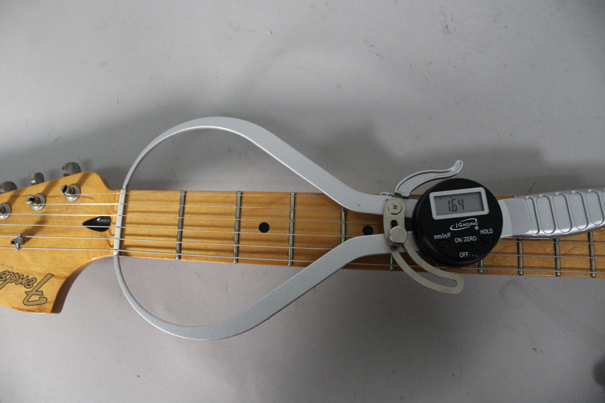Close-up of the maple fretboard and headstock, with a digital caliper measuring the fret height at 1.64mm.