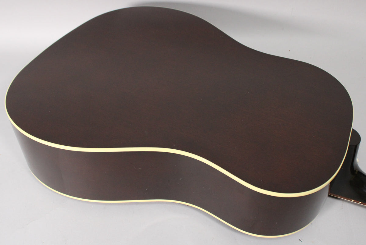 The dark brown acoustic guitar body is angled, showing the back and side with cream binding, and a hint of the neck.