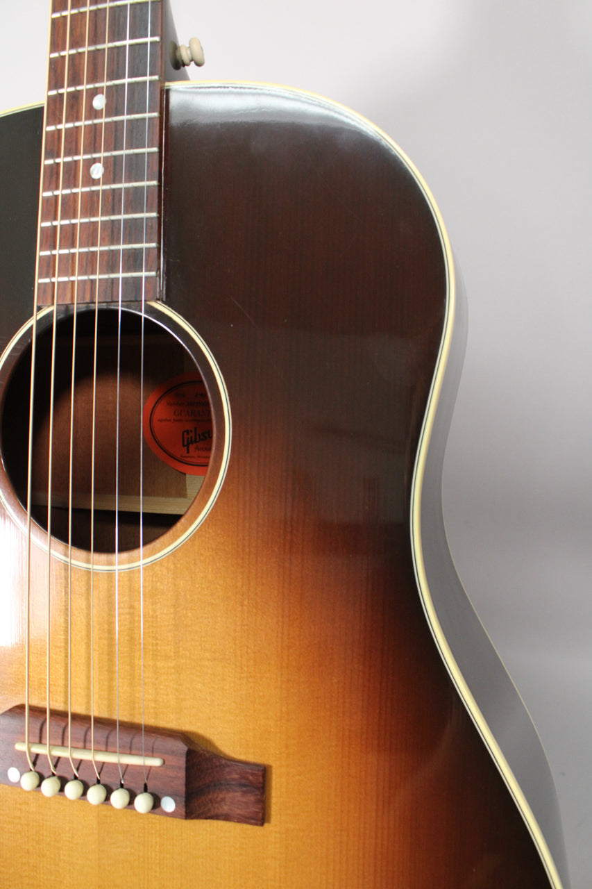Close-up of the sunburst body, showing the soundhole, bridge, lower fretboard, and light pick scratches on the upper bout.