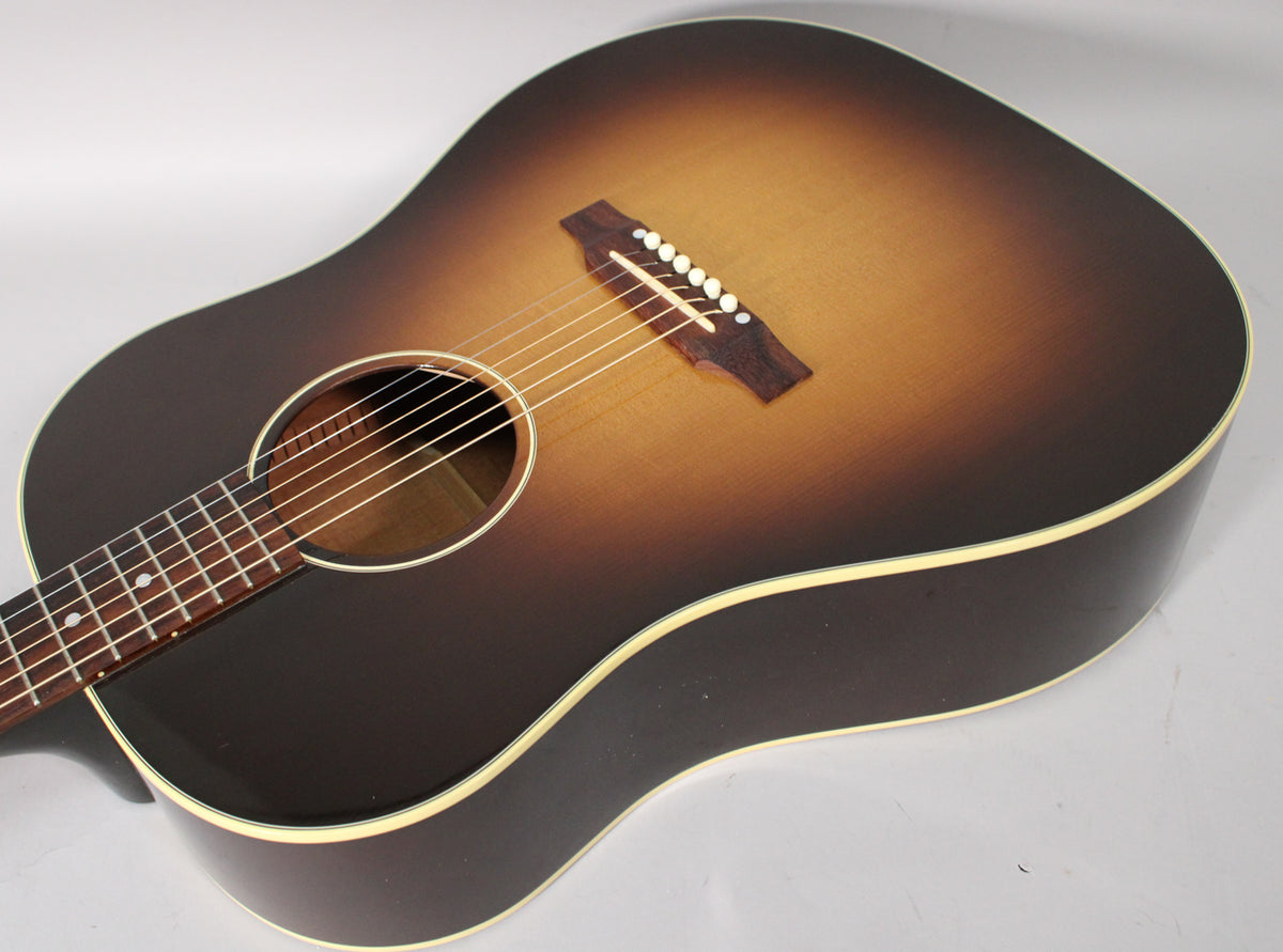 The acoustic guitar's sunburst body, with a dark brown edge fading to amber, is angled to show the soundhole and bridge.