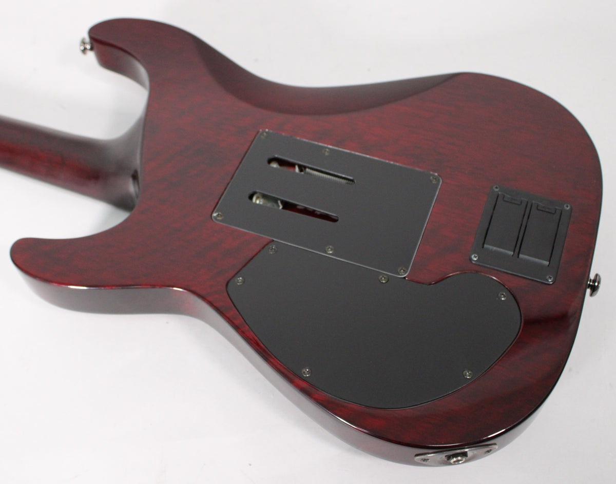 The guitar's back, showing a translucent black cherry finish, black control cavity covers, and a black tremolo spring cover.