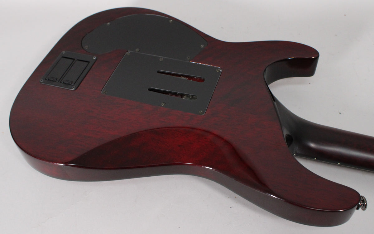 The back of a deep red electric guitar, showing the dark wood grain, black control covers, and neck joint.
