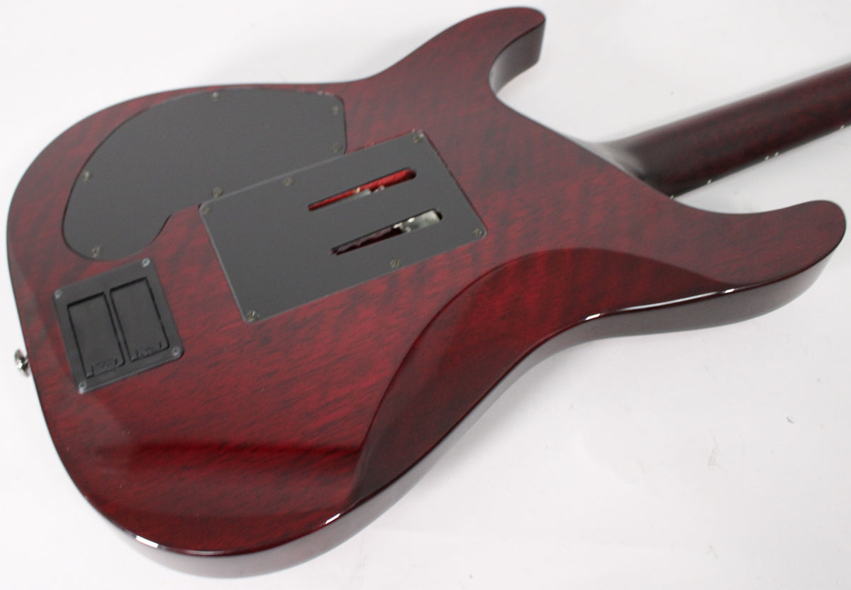 The guitar's back, in a glossy black cherry finish with visible wood grain, shows two black control plates and two battery compartments.