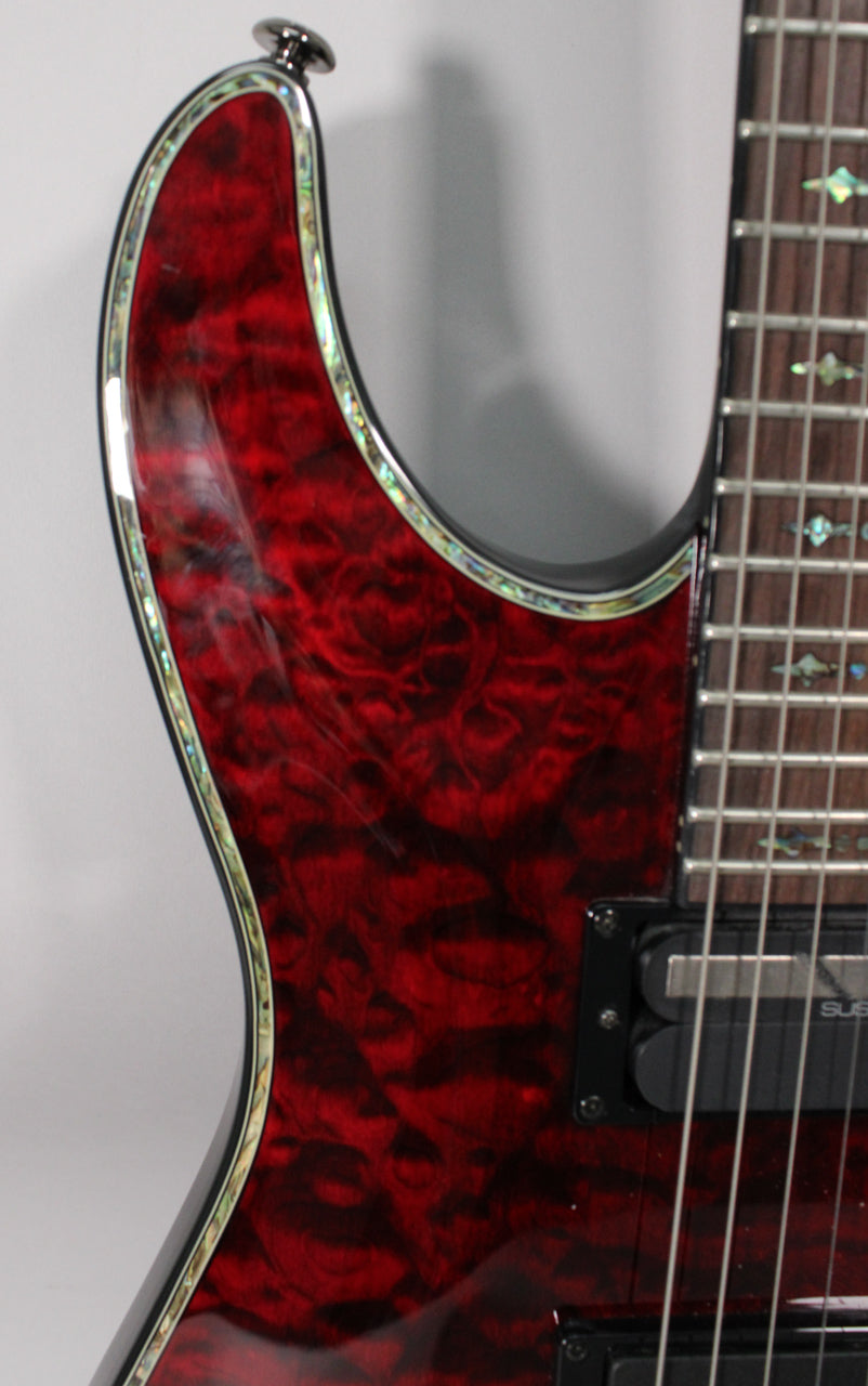 Close-up of the guitar's upper body, showing the glossy black cherry finish with abalone binding and a portion of the fretboard.