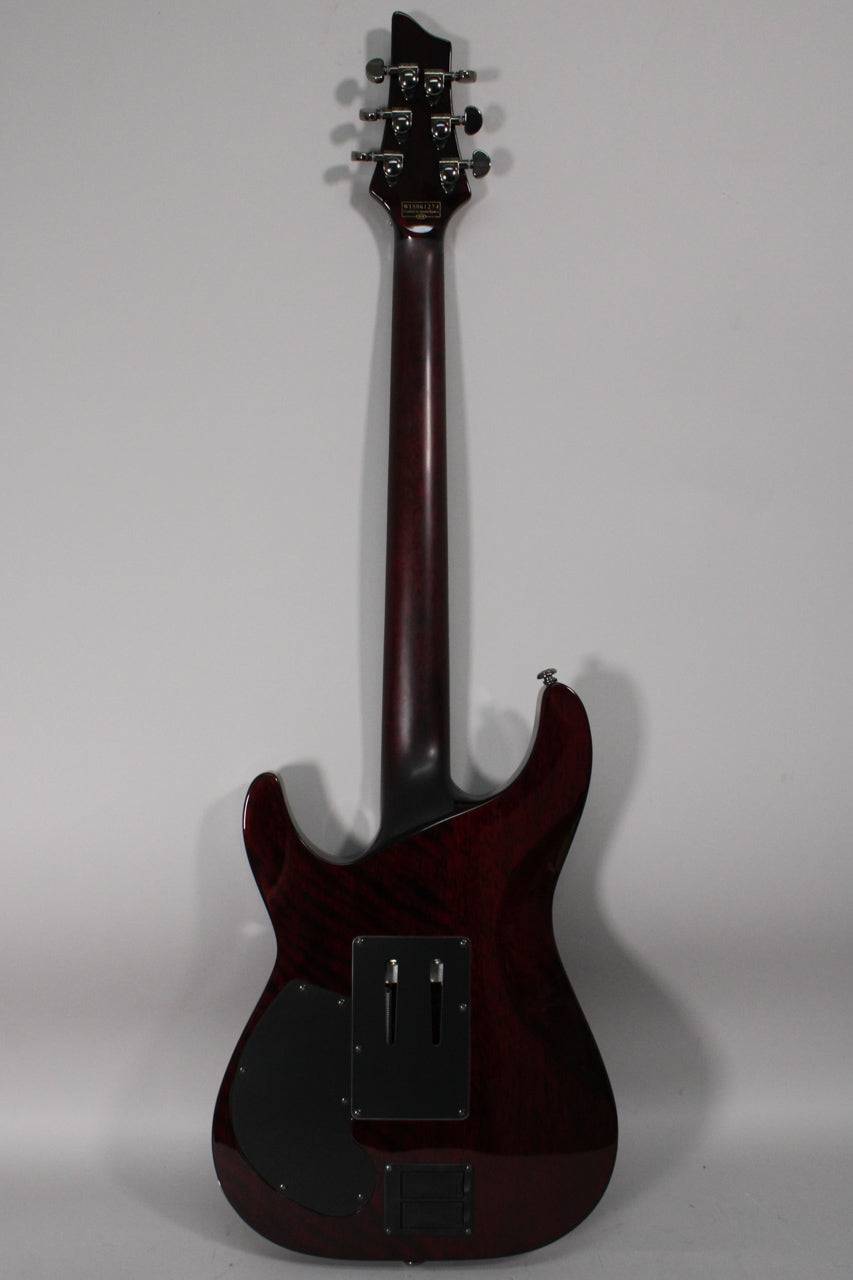 The guitar's back is visible, showing a dark cherry burst finish, black control cavity covers, and a dark neck with matching headstock.