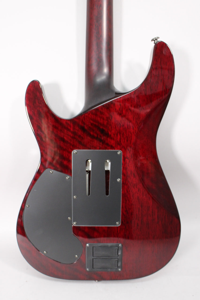 The back of a deep red, flamed maple guitar body with a dark neck, black control plates, and a battery compartment.