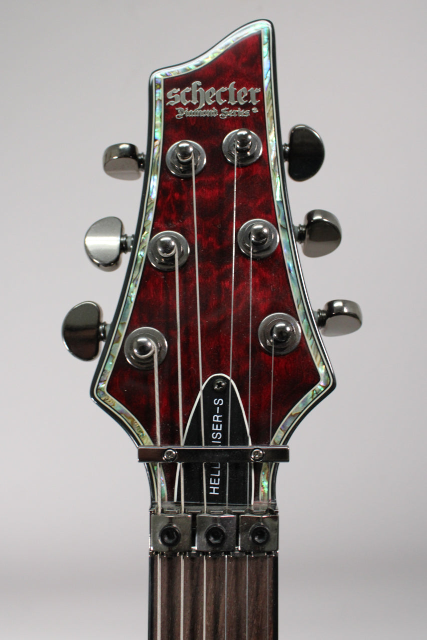 The guitar's headstock, with a black cherry burl finish and abalone binding, features six black tuners and a locking nut.