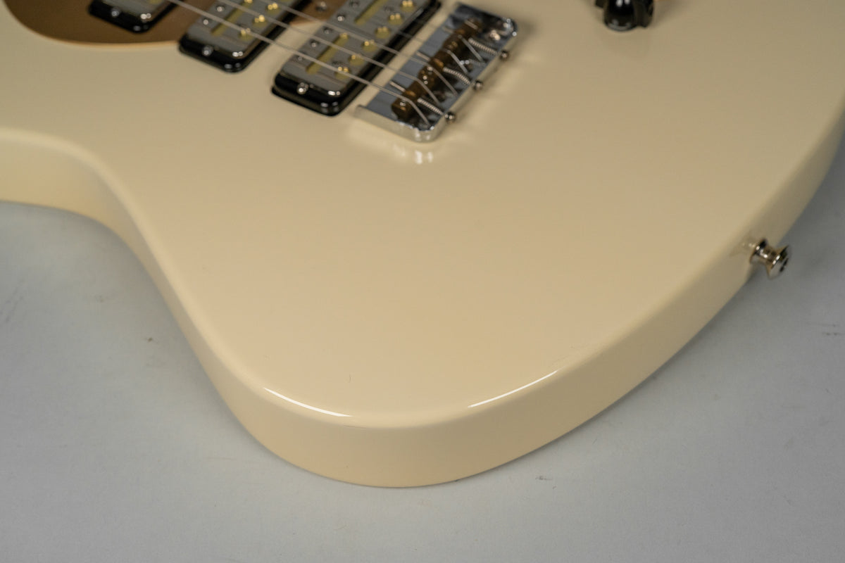 Close-up of the guitar's antique white body, showing the lower bout, chrome bridge, and two gold foil pickups on a gold pickguard.