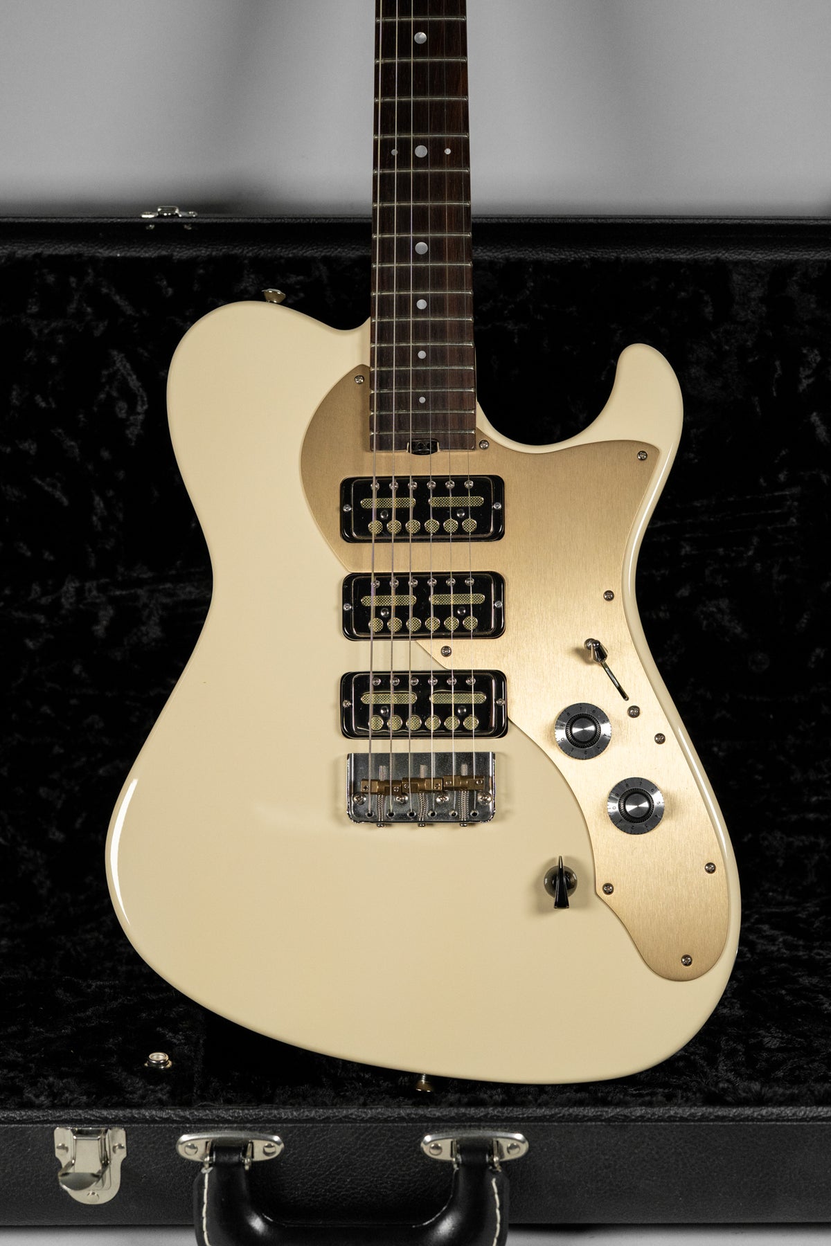 Antique white electric guitar with a gold pickguard, three black Lollar Gold Foil pickups, and two chrome control knobs.