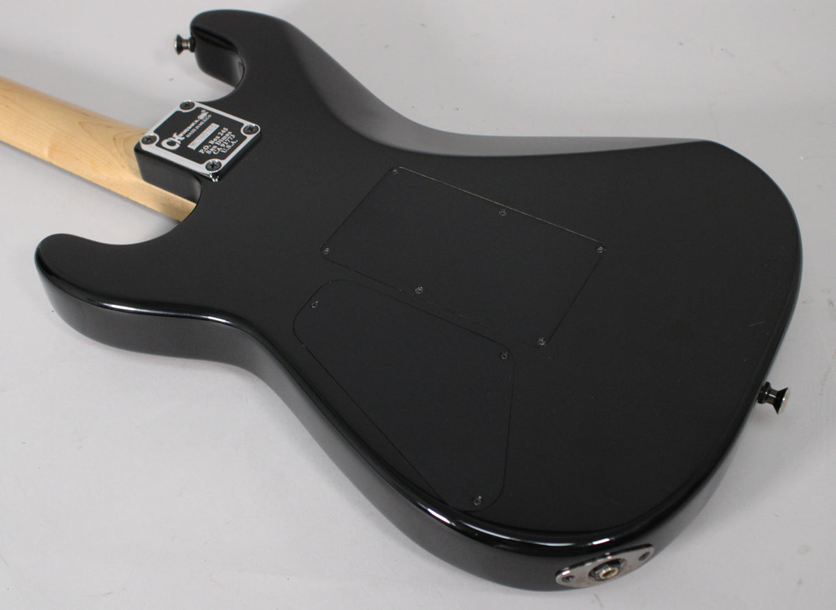 The guitar's glossy black back shows a light maple neck, chrome neck plate, two control cavity covers, and an output jack.