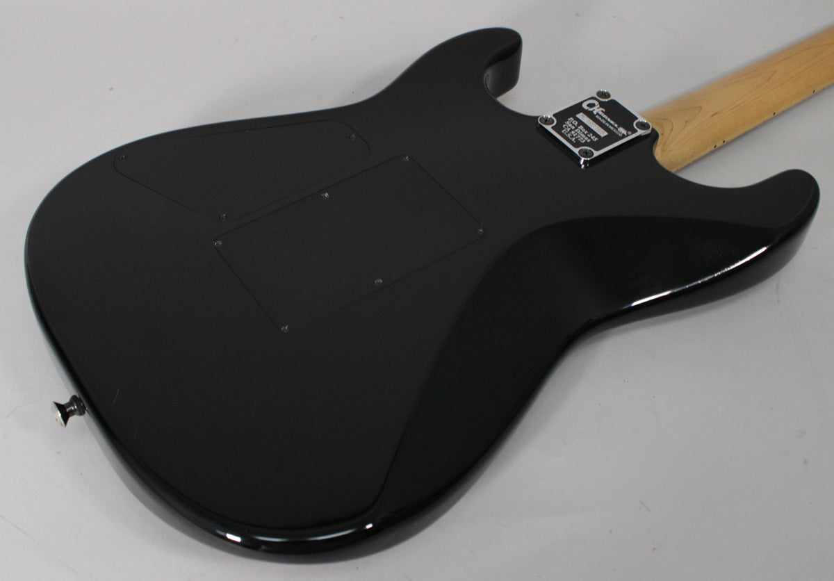 The guitar's back is shown, featuring a glossy black finish, two control cavity covers, a chrome neck plate, and a natural maple neck.