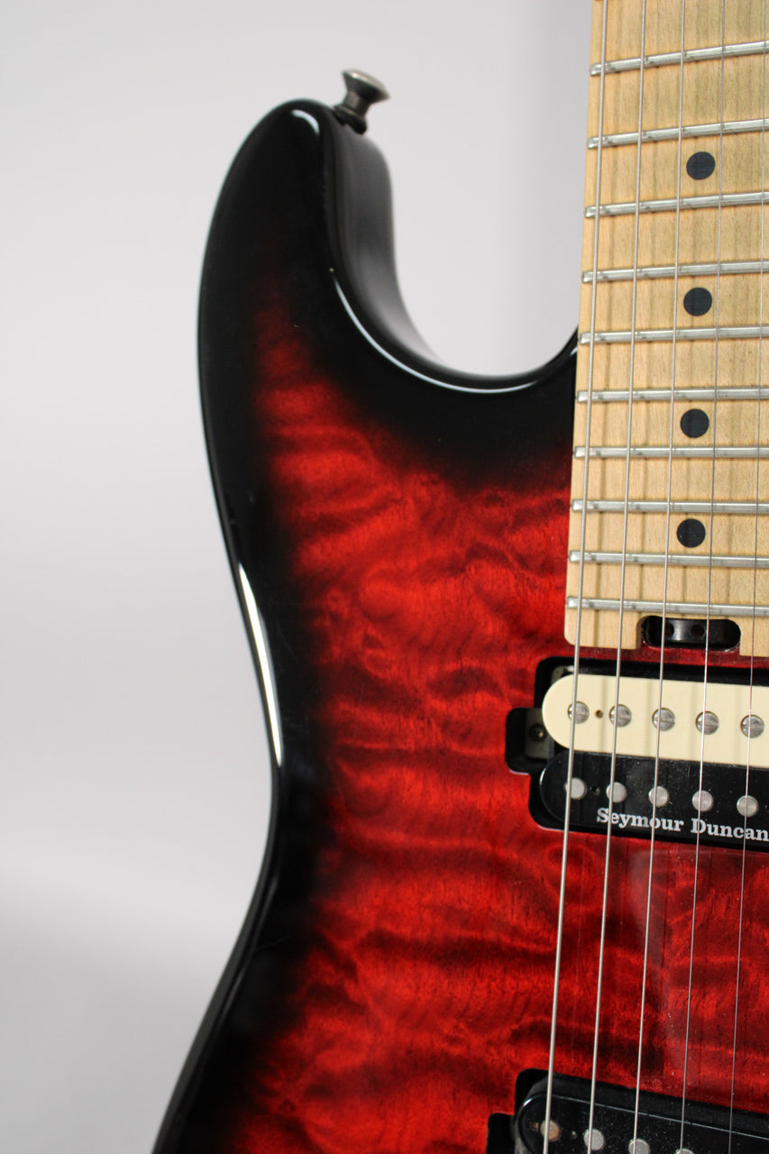 Close-up of the guitar's upper bout, showing the transparent red burst finish, maple fretboard, and cream neck humbucker.