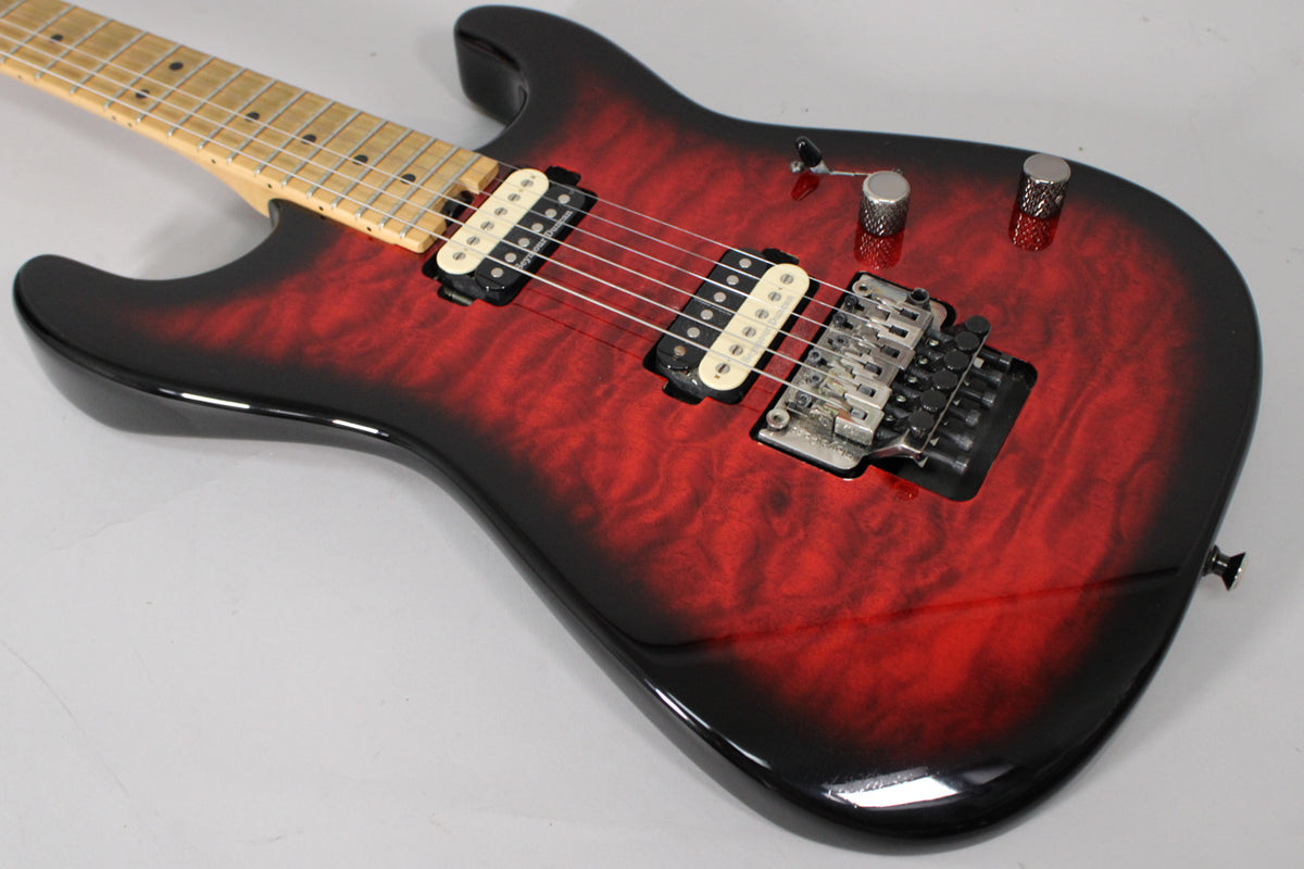 The guitar's translucent red burst body with black edges is angled, showing a maple neck, two humbuckers, and a Floyd Rose tremolo.