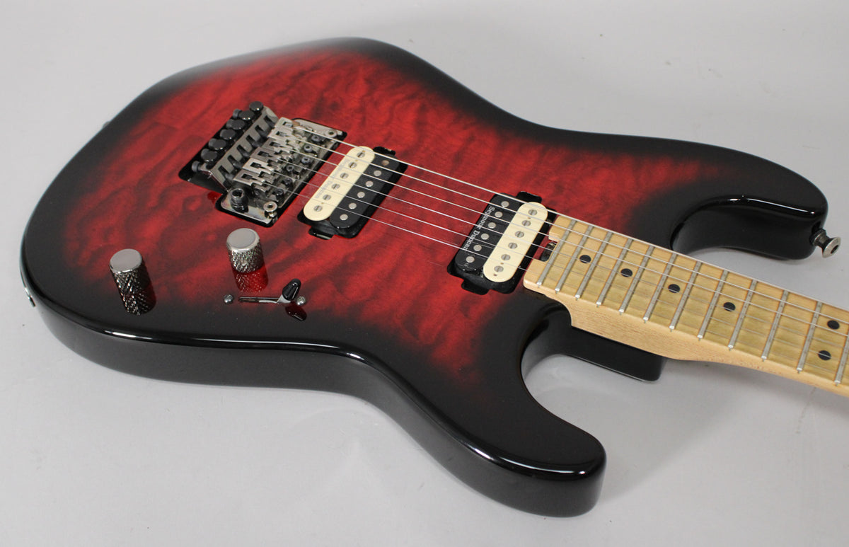 The electric guitar's body, in transparent red burst with black edges, is angled to show its two cream-colored humbucker pickups.