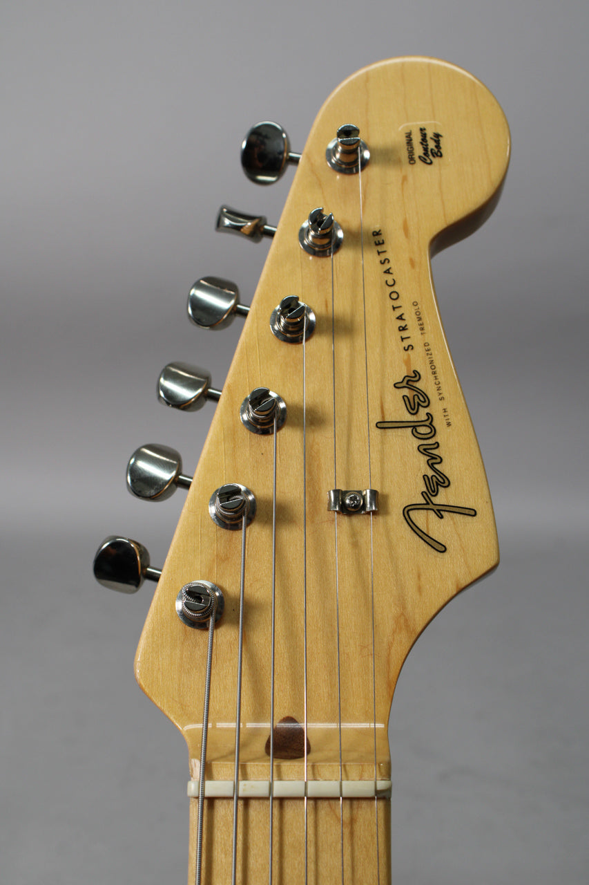 Close-up of the guitar's light wood headstock and top of the neck, showing six chrome tuners and a string tree.