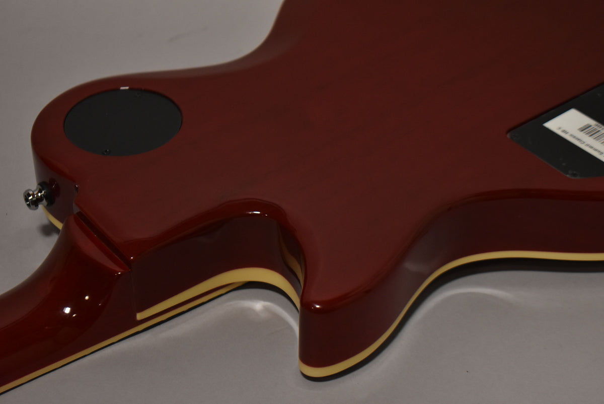 The back of the cherry burst guitar body is shown, revealing a black circular control plate and a cream binding around the edges.