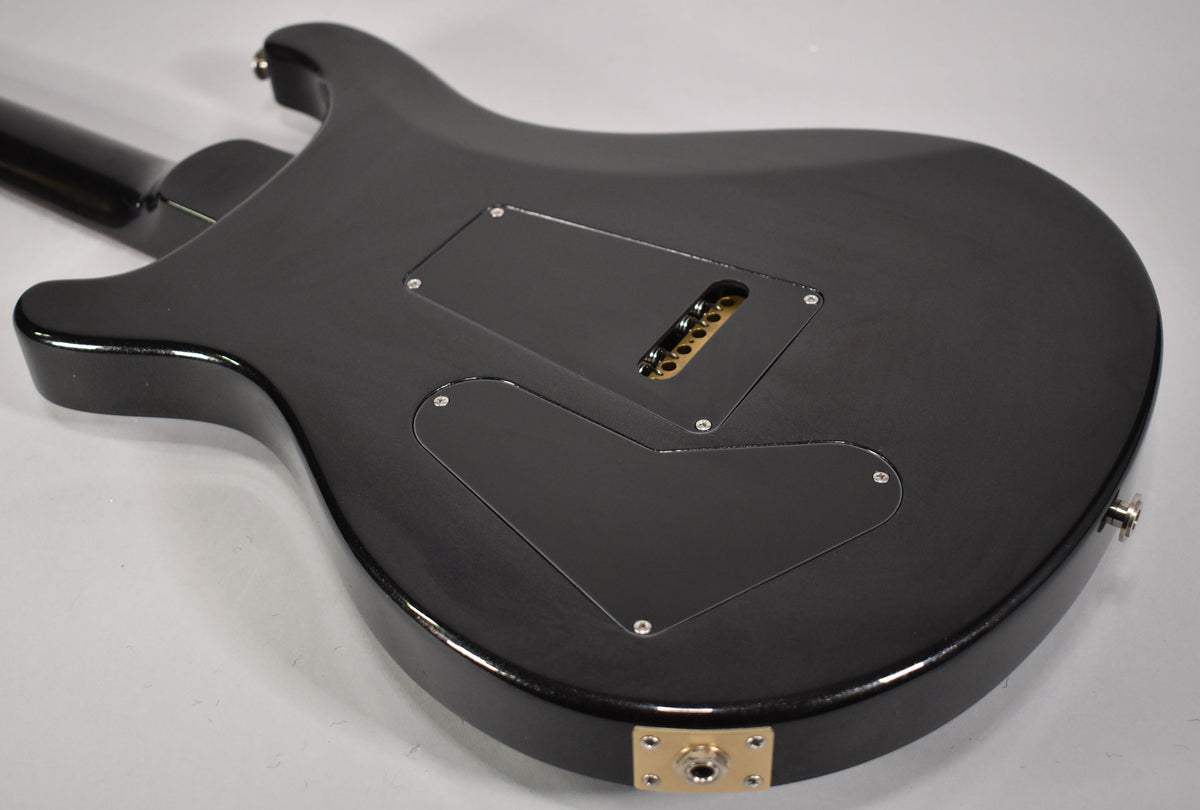 The guitar's black back has a satin finish, with two control cavity covers and a tremolo spring cover, all black.