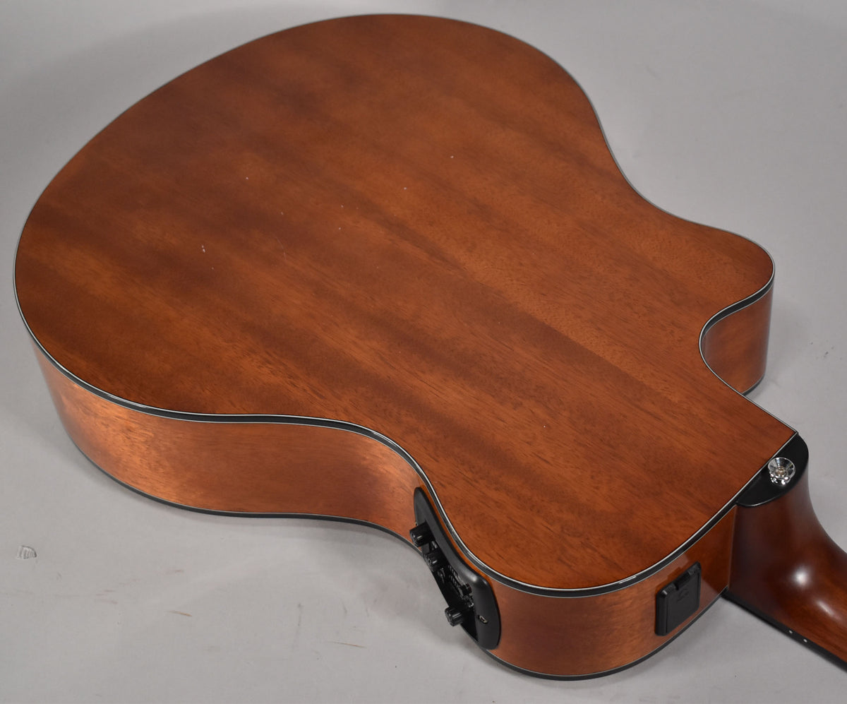 The classical guitar's mahogany back and sides are shown from above, with a black preamp and output jack visible on the lower bout.