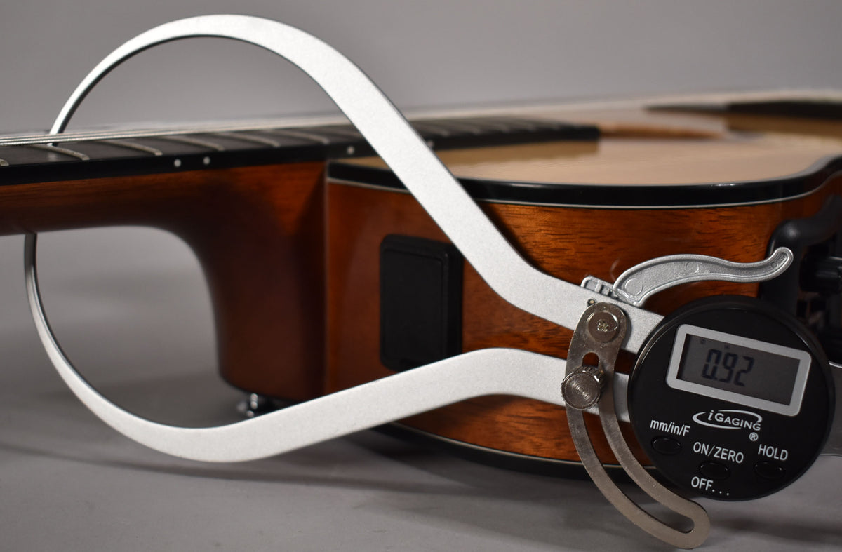 A digital caliper measures the string height at the 12th fret of the classical guitar, showing 0.92mm.