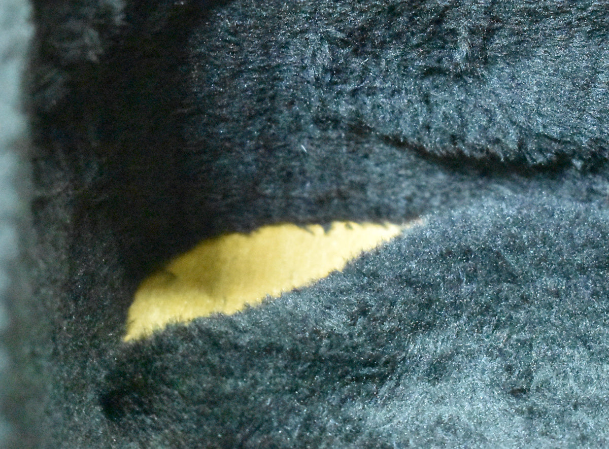 A close-up of the guitar's hard shell case interior, showing dark blue plush lining with a worn, exposed yellow section.