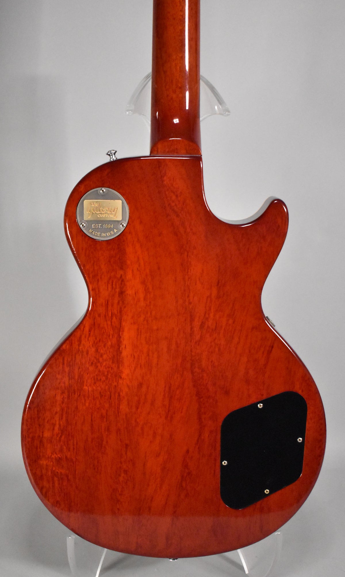 The guitar's back, in a faded tobacco finish, shows a control cavity cover and a gold medallion at the neck joint.