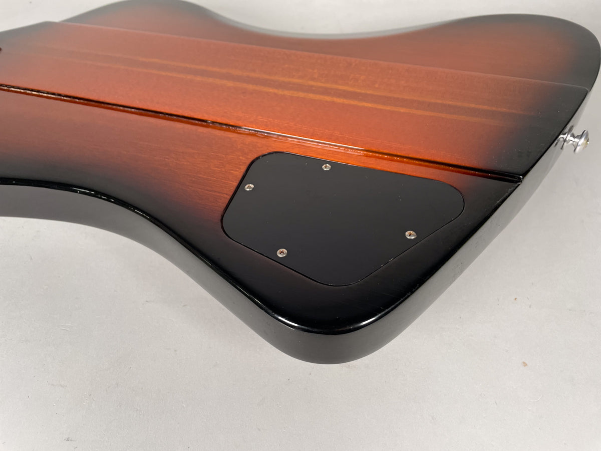 Close-up of the guitar's sunburst body back, showing the black control cavity cover and a chrome strap button on the lower horn.