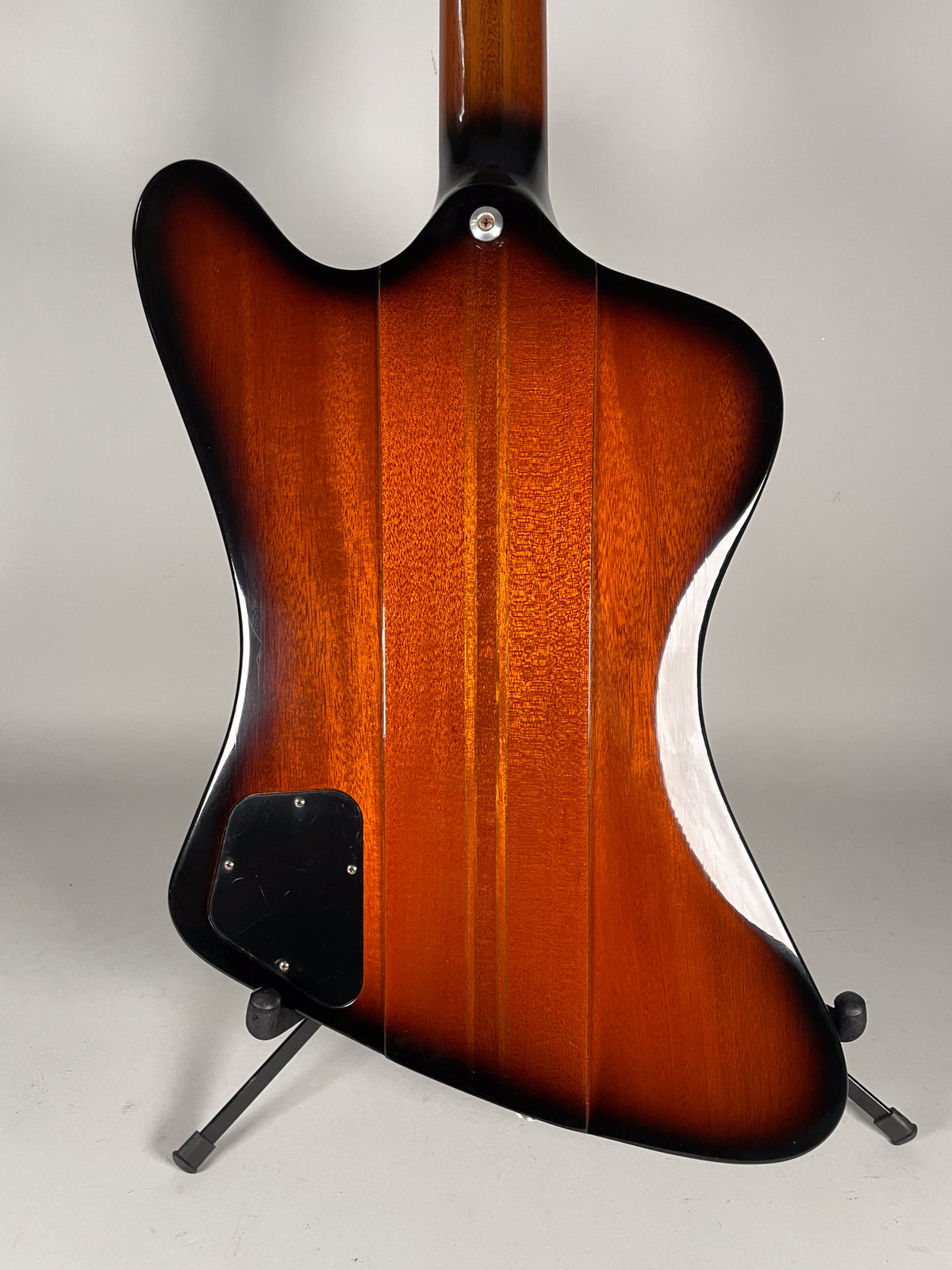 The guitar's back shows a glossy sunburst finish with visible wood grain, a black control plate, and light surface scratches.