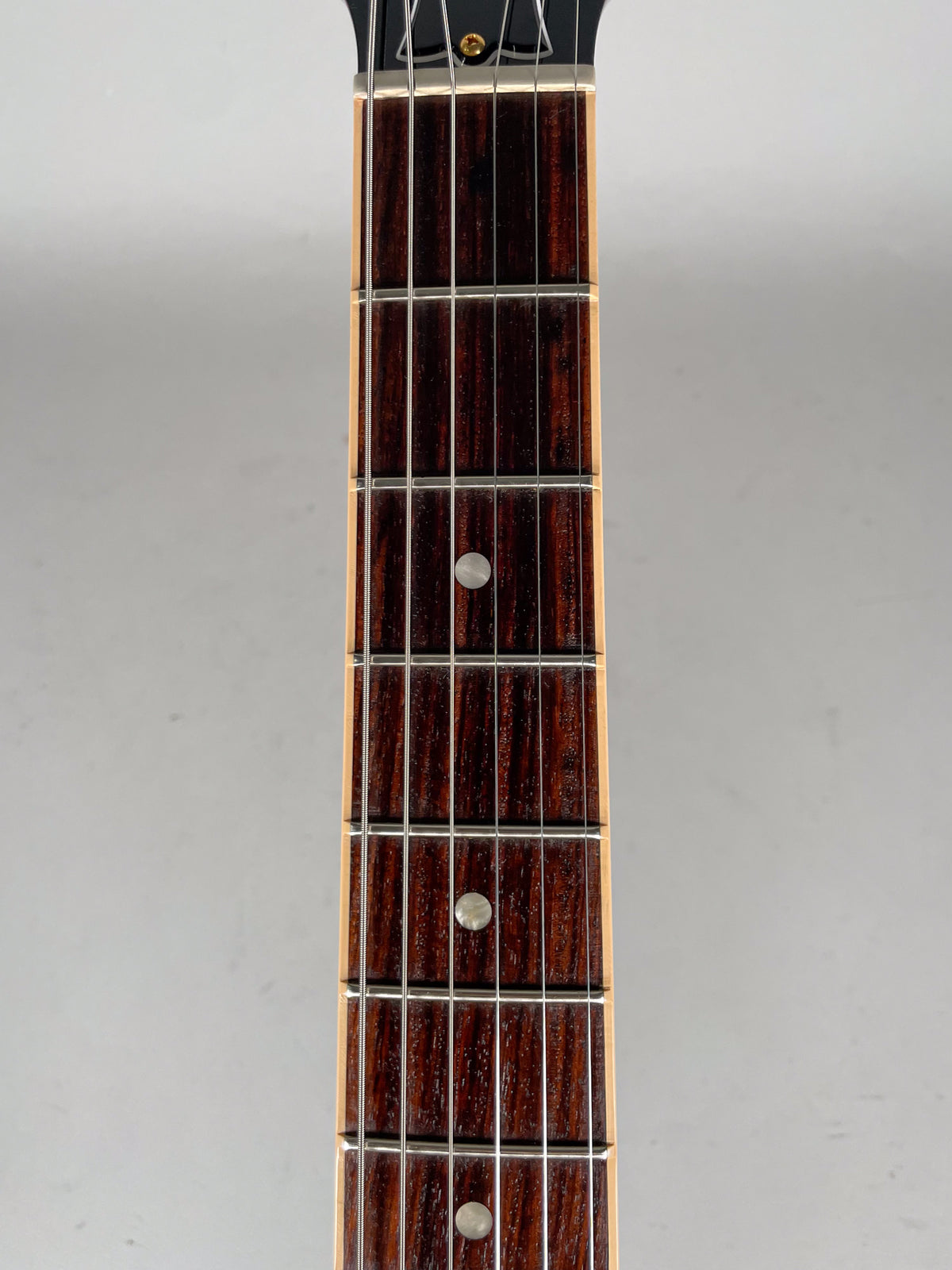 Close-up of the guitar's dark rosewood fretboard with silver frets and dot inlays, showing light wear on the frets.