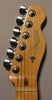 Close-up of the guitar's light-colored headstock, showing six chrome tuners, a string tree, and a dark wood string guide.