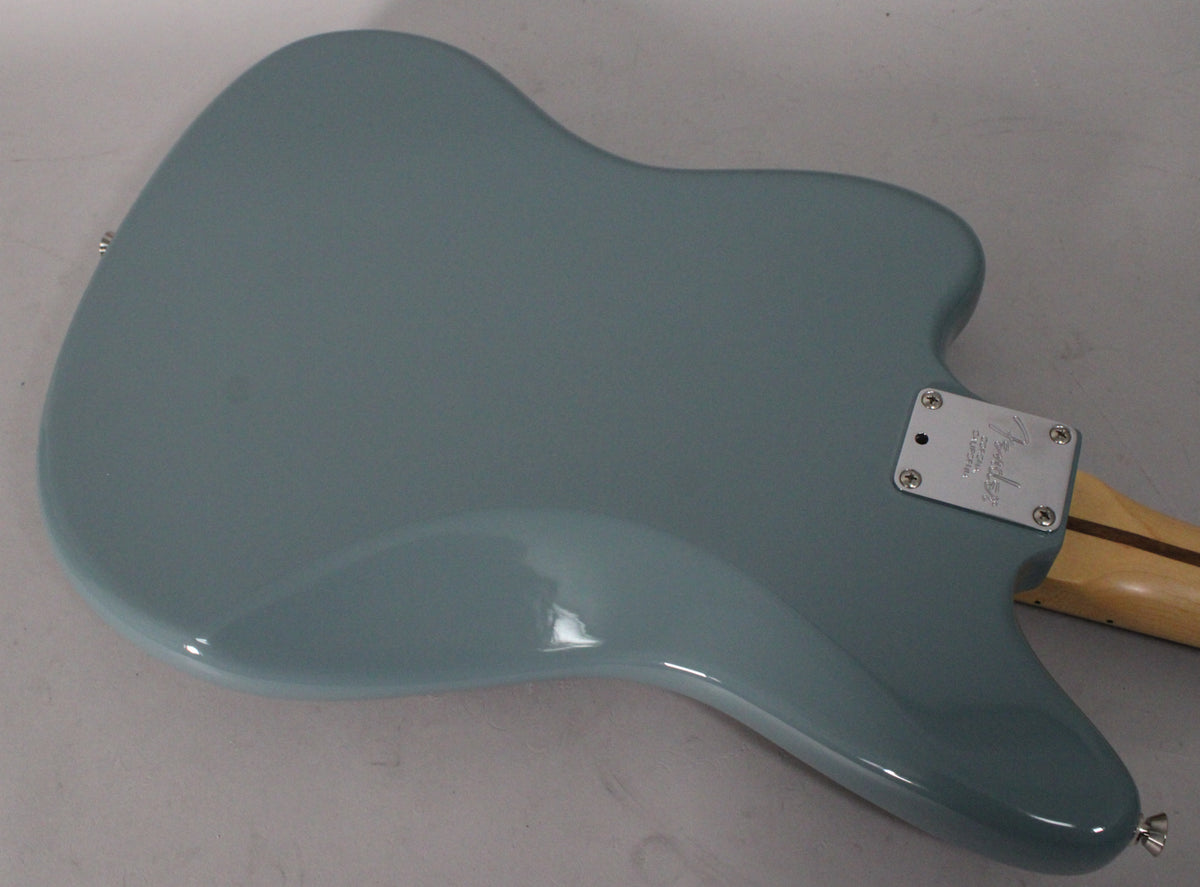 The back of a Sonic Grey Jaguar body, showing the neck plate, strap button, and a small ding on the lower bout.
