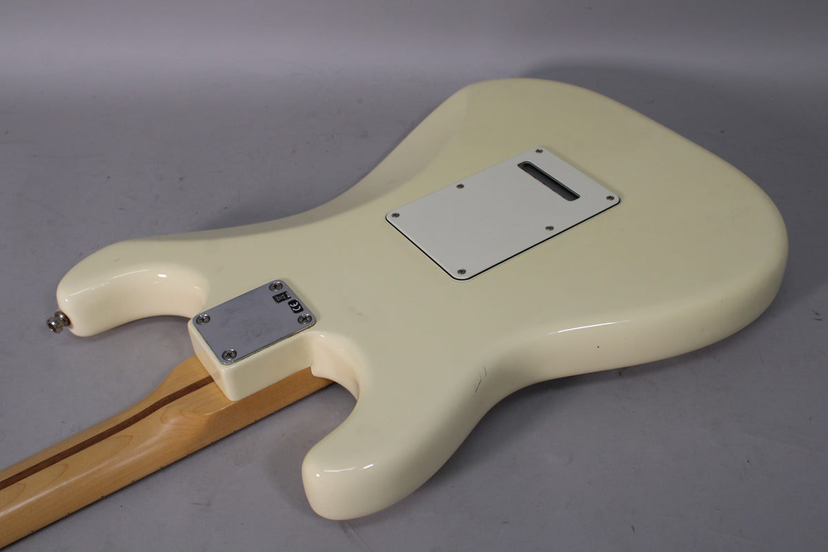 The back of an Olympic White Stratocaster body, showing the tremolo cavity cover, neck plate, and some minor scuffs.