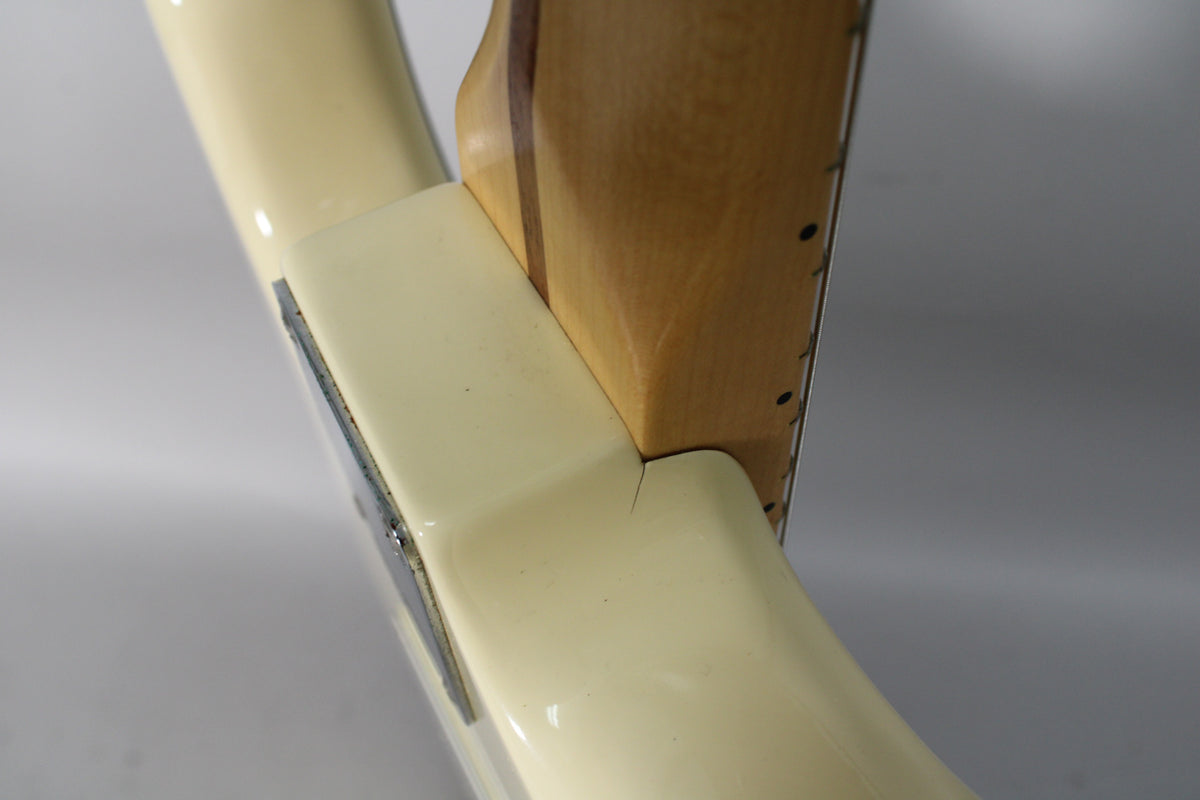 Close-up of the Olympic White body and neck joint, showing a visible finish crack extending from the neck pocket.