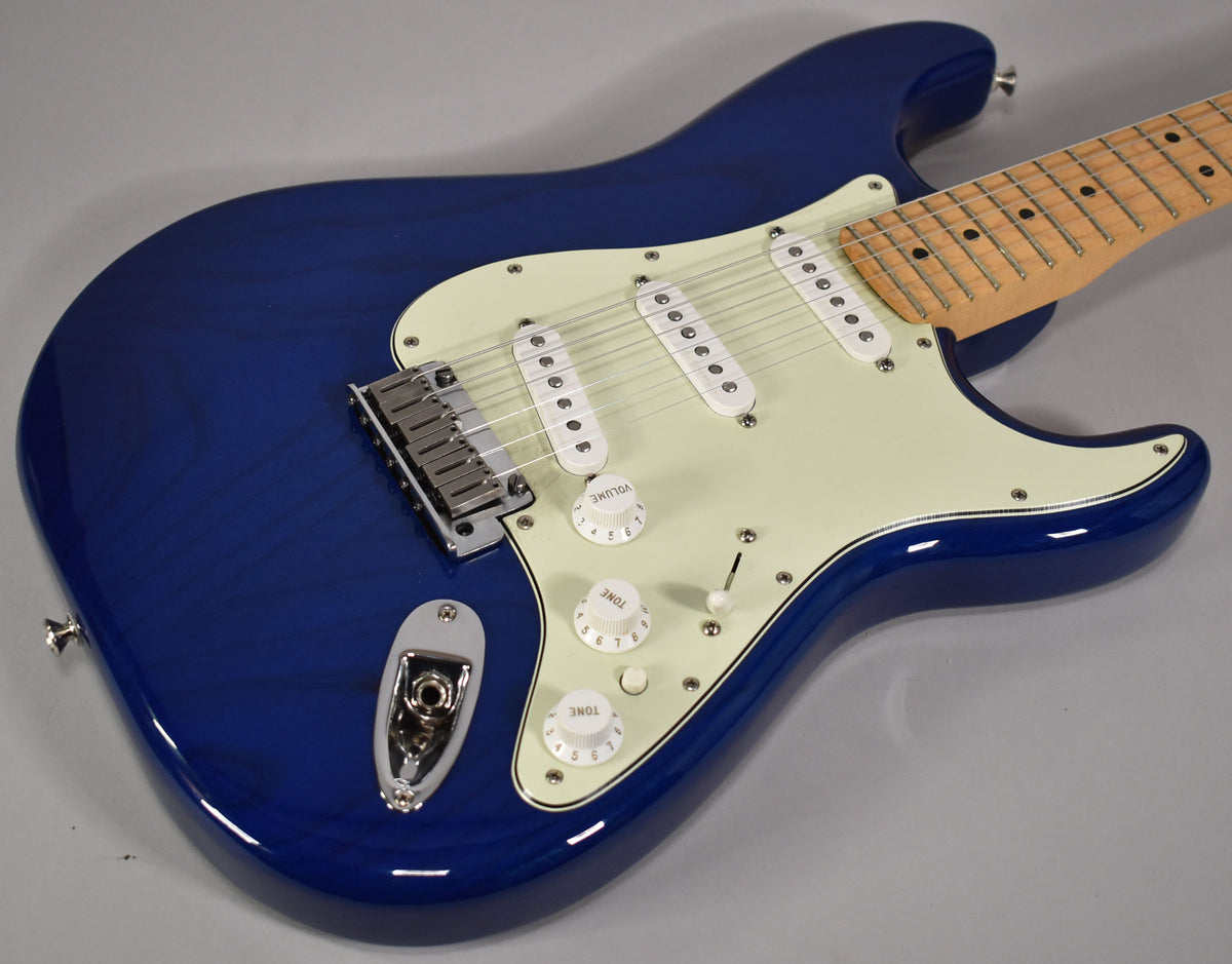 Angled view of a sapphire blue Stratocaster with a maple fretboard, cream pickguard, three single-coil pickups, and chrome hardware.