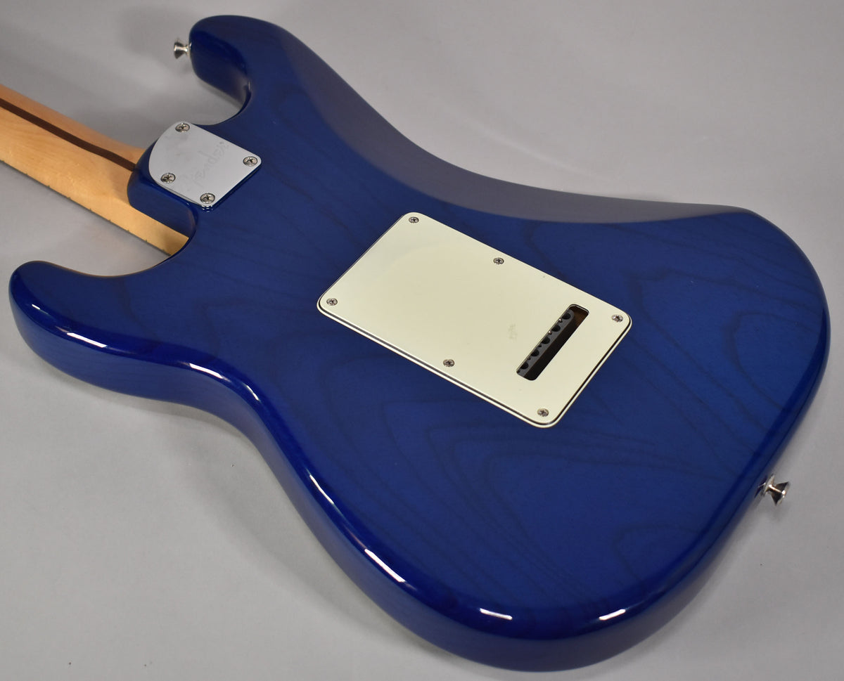 Rear view of a sapphire blue Stratocaster body, showing the neck plate, tremolo cover, and visible wood grain through the finish.
