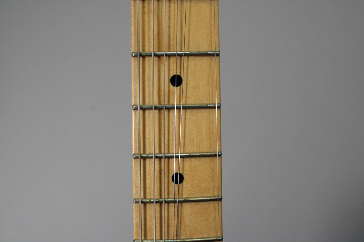 Close-up of a guitar fretboard with strings, frets, and two black dot inlays on a light gray background.