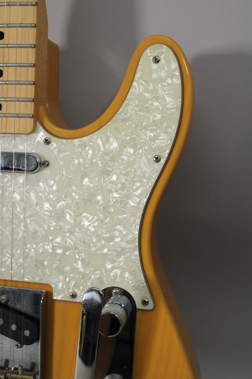 Close-up of the Telecaster's butterscotch body and pearloid pickguard, showing the neck pickup and Bigsby vibrato arm.