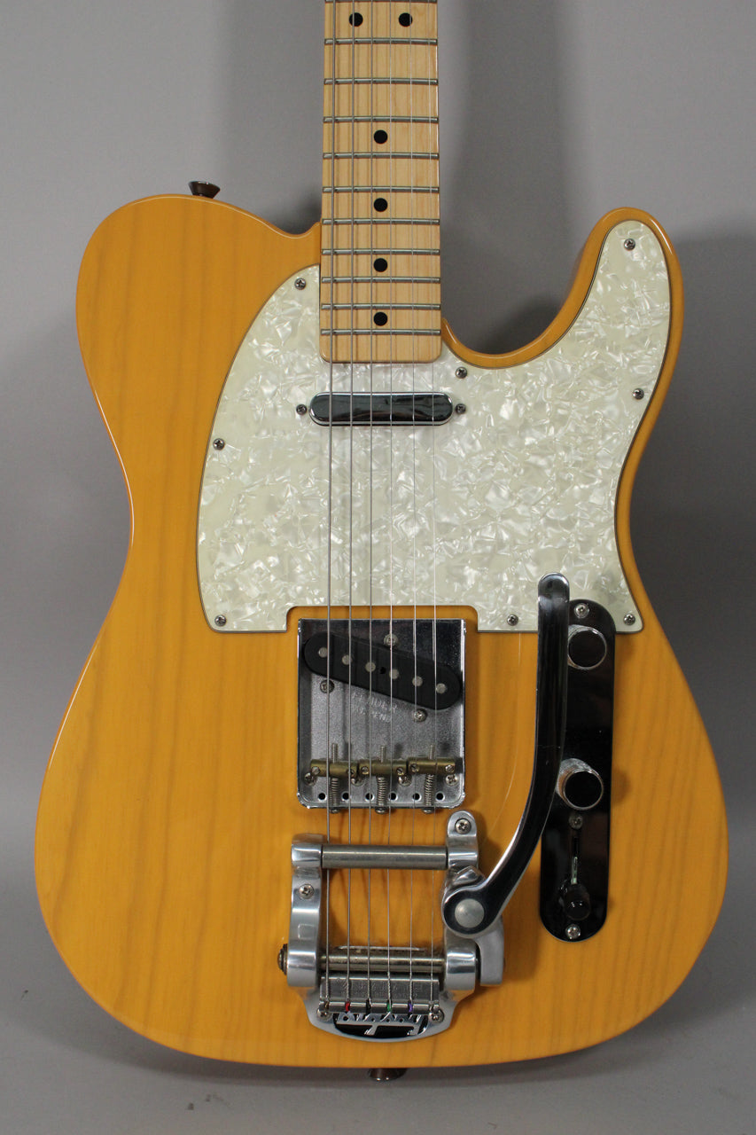 Full-frame view of the butterscotch blonde Telecaster, showing its pearloid pickguard, maple fretboard, and Bigsby vibrato.