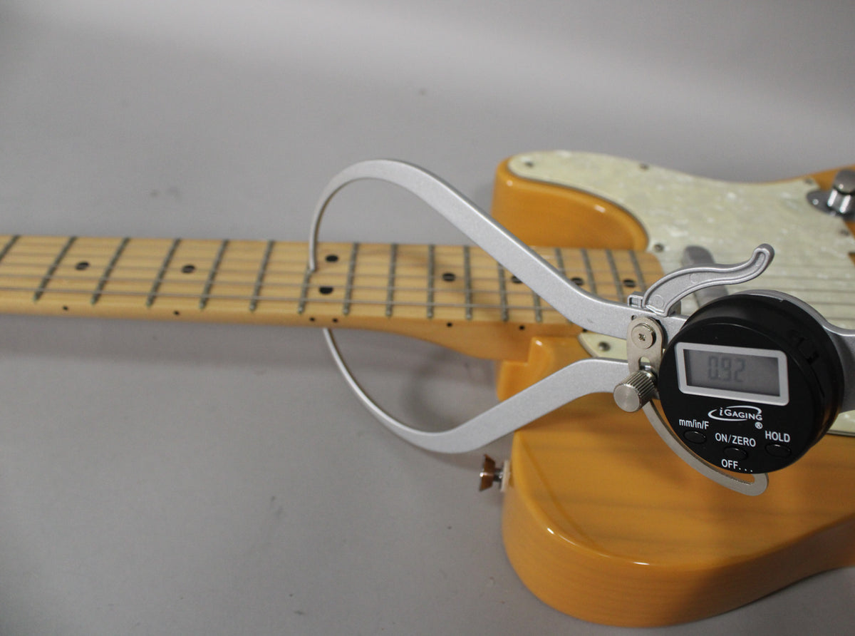 A digital caliper measures the neck thickness at the 12th fret of the butterscotch blonde Telecaster, showing 0.92 inches.