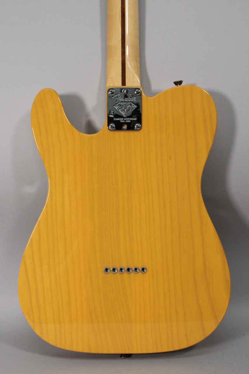 The back of a butterscotch blonde Telecaster shows wood grain, a chrome neck plate, and six string ferrules.