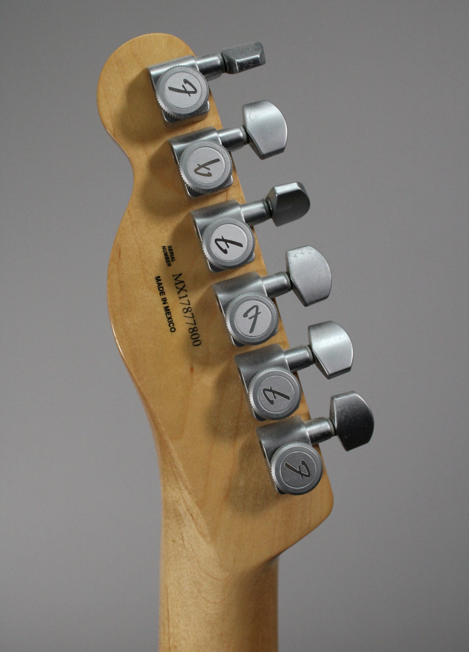 The back of the guitar's headstock and neck, showing six brushed chrome tuners with light wear on the buttons.