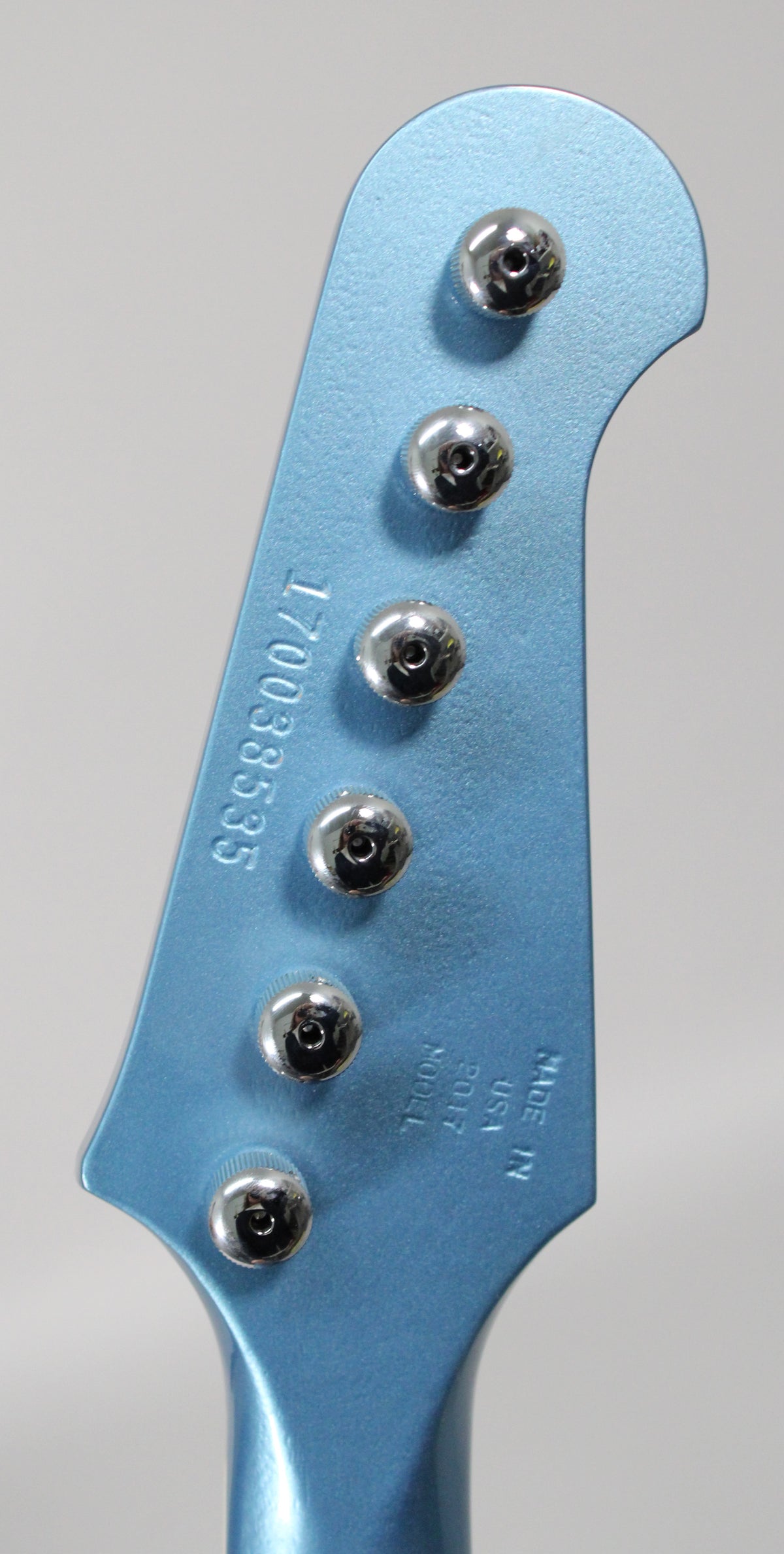 The Pelham Blue headstock, with a matte finish, features six chrome tuners and a visible serial number.