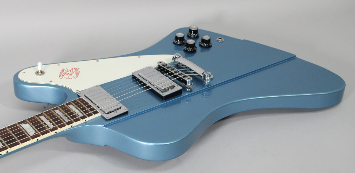 Close-up of the Pelham Blue body, showing the white pickguard with red bird graphic, chrome hardware, and four black control knobs.