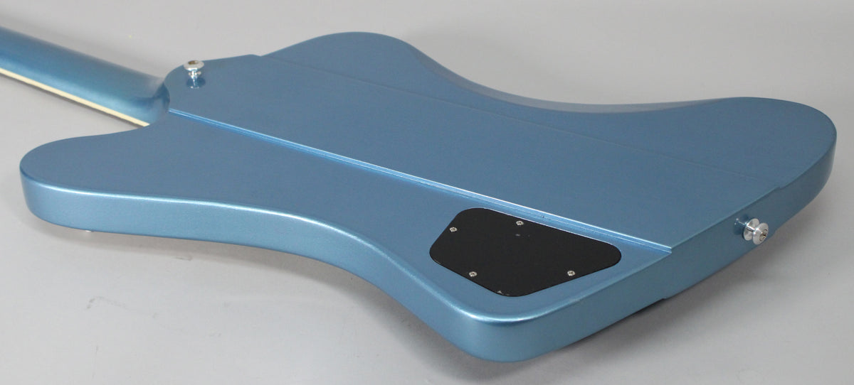 The back of a Pelham Blue Firebird guitar, showing the neck joint, body contours, and a black control cavity cover.