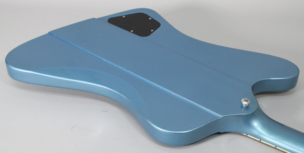 The Pelham Blue Firebird's back, showing the neck joint, strap button, and black control cavity cover, with a few minor scuffs.