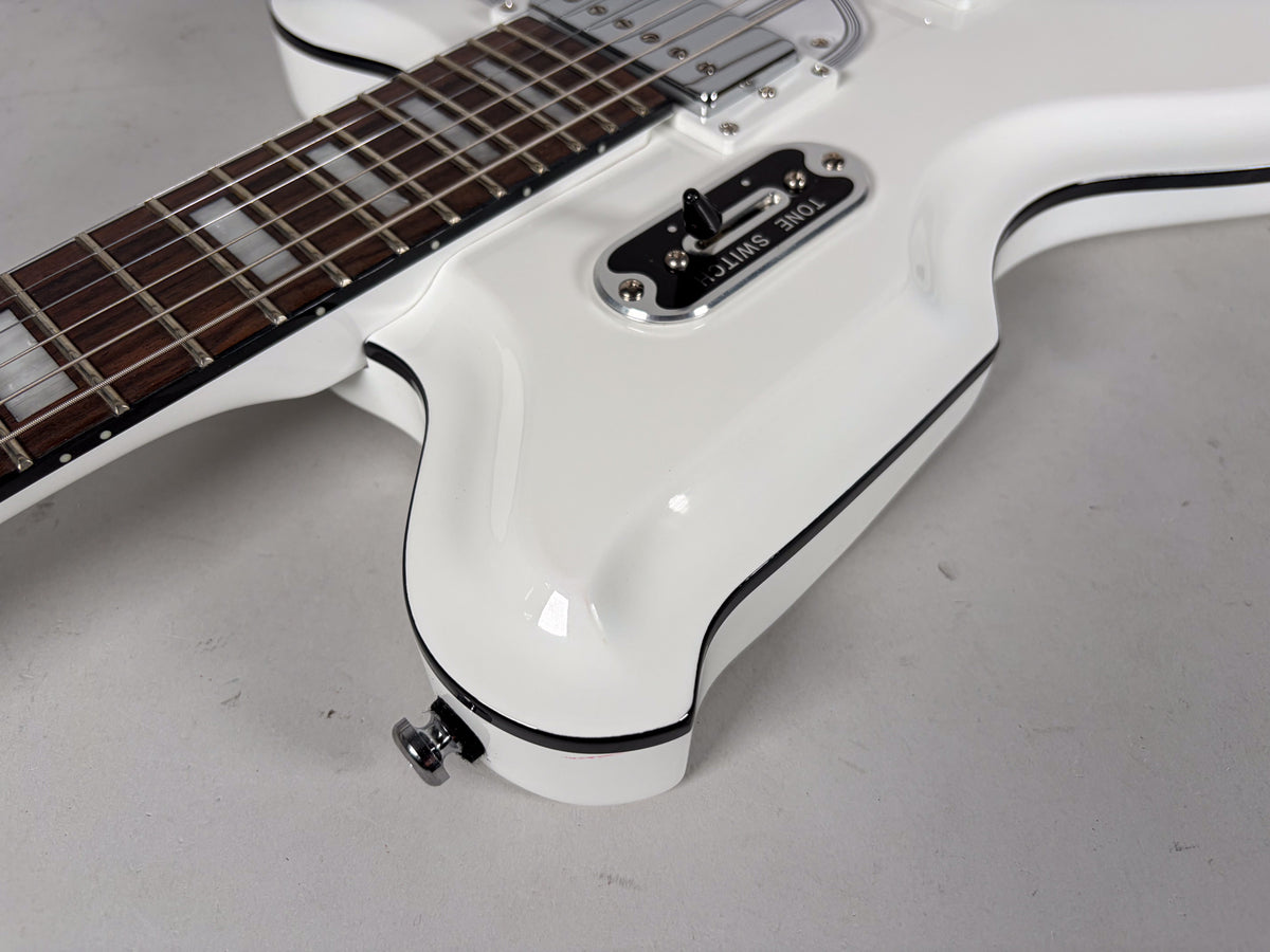 Close-up of the glossy white guitar body with black binding, showing the dark fretboard with block inlays and a chrome tone switch.