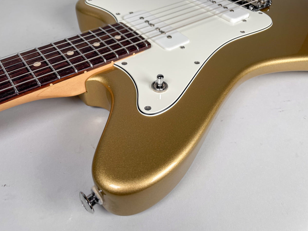 Close-up of a gold sparkle guitar body with a white pickguard, two white S90 pickups, a three-way toggle switch, and a rosewood fretboard.