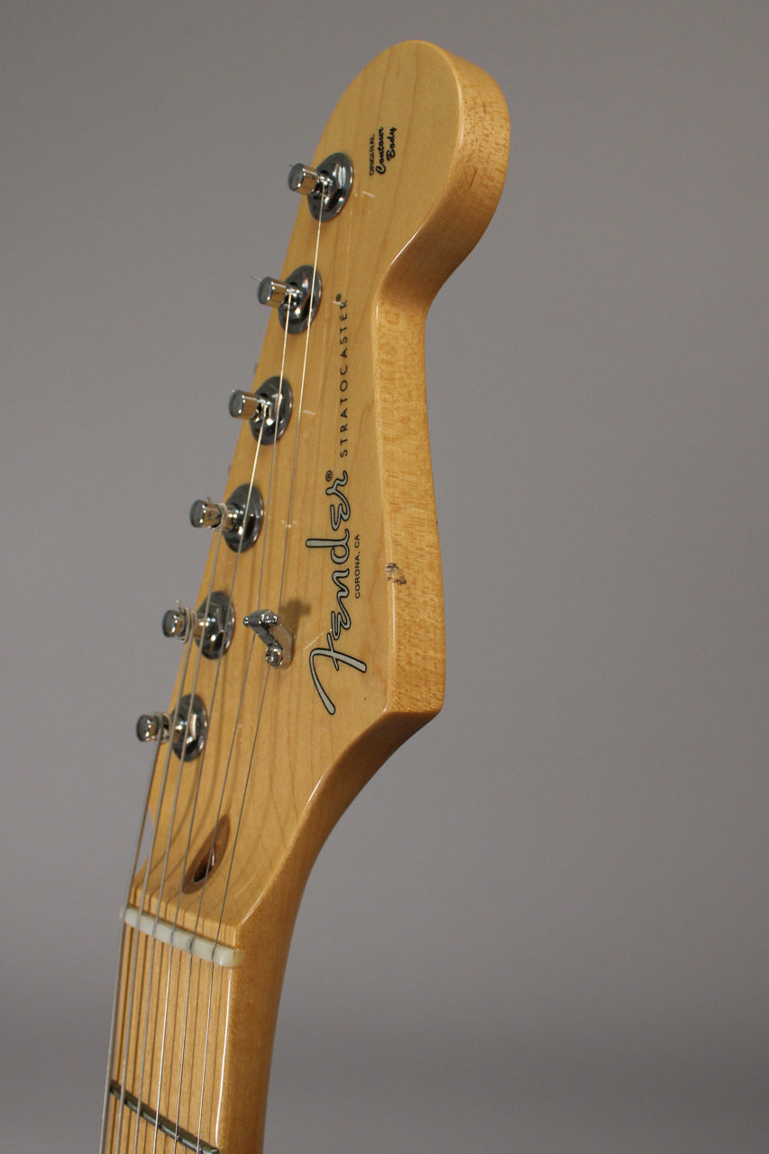 Angled close-up of the light maple headstock with six chrome tuners, showing a small ding on the front face.